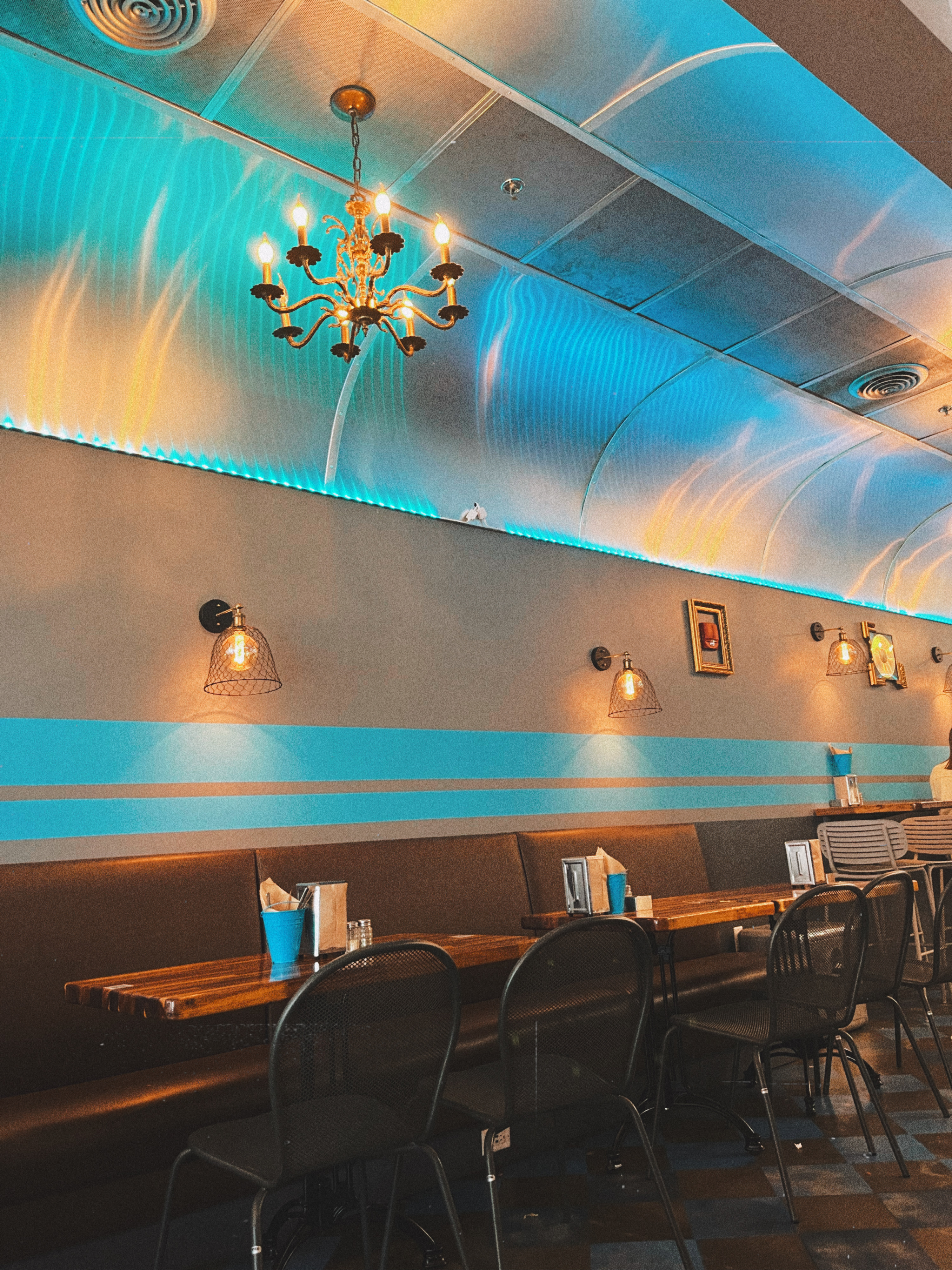 the inside of Treylor park which looks like a trailer with eclectic decor such as a chandelier