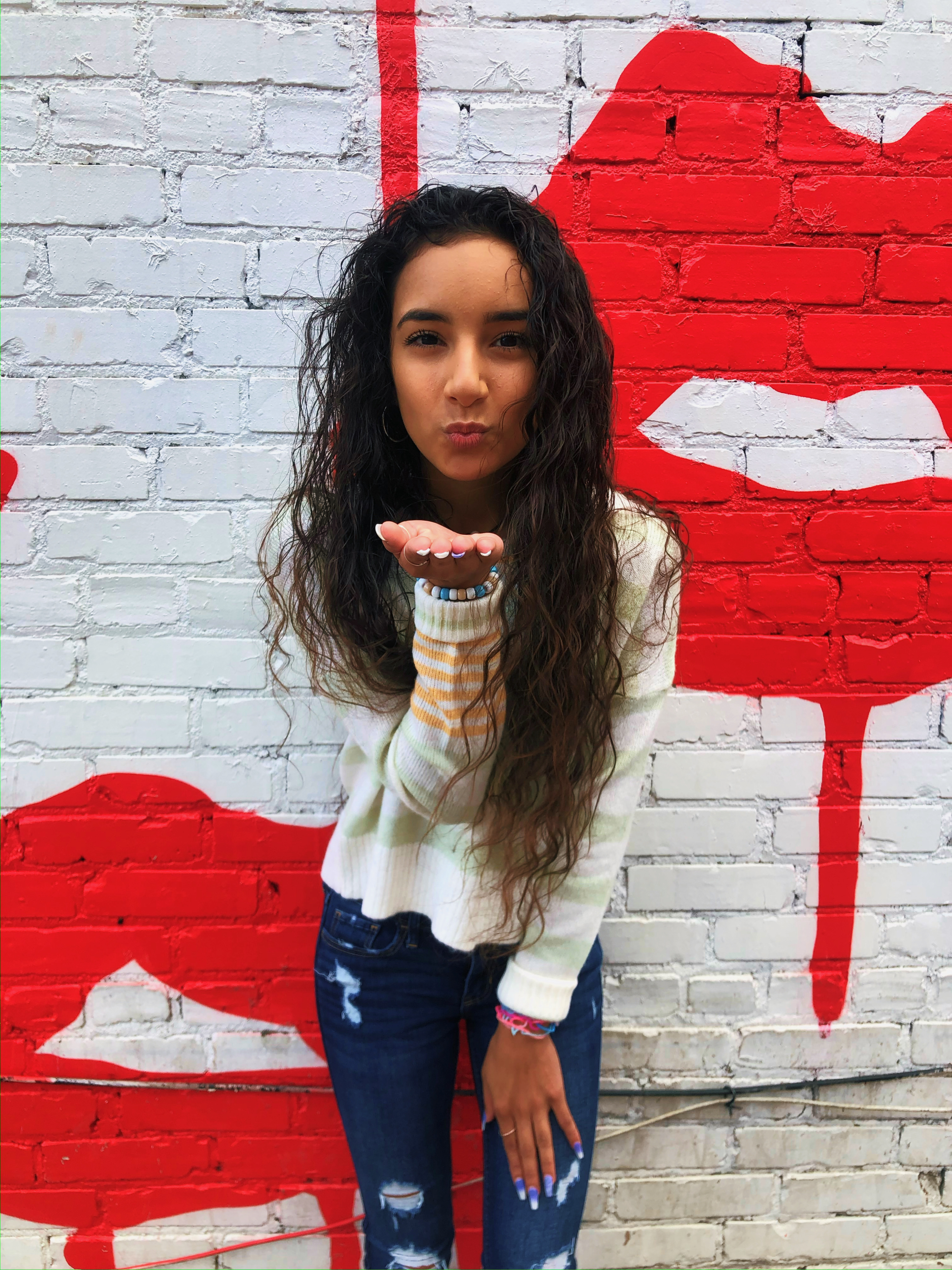 Girl blowing a kiss in front of Nashville drippy lips mural