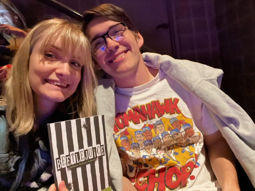 My boyfriend and I holding a Beetlejuice The Musical Playbill