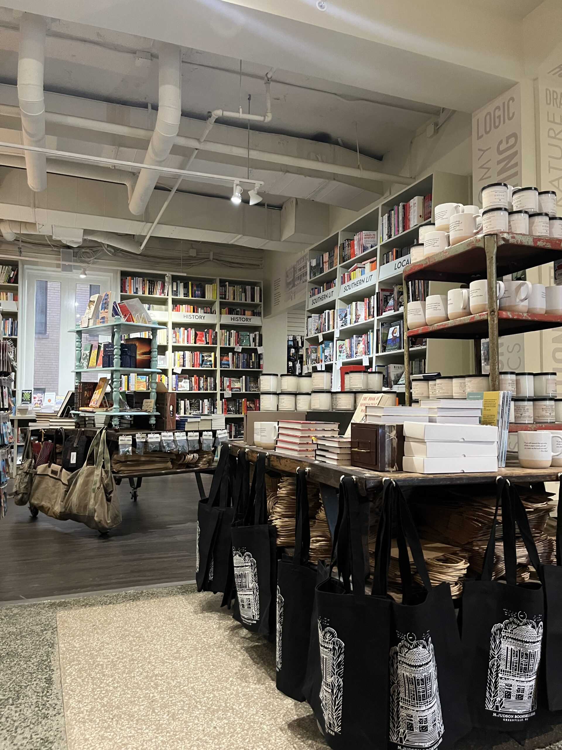 The inside of M.Judson Booksellers in Greenville, South Carolina (bookshelves and tables full of books and coffee mugs) 