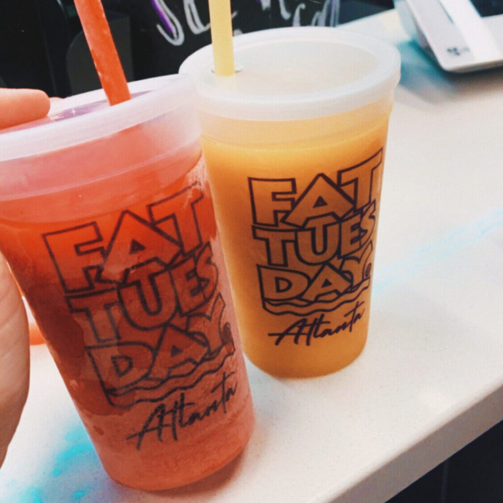 2 frozen alcoholic beverages bought at Fat Tuesday, one is red and one is yellow