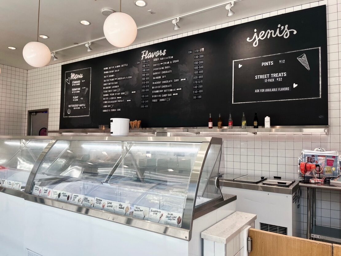 the menu at Jeni's Splendid Ice Creams  is displayed on a black board on a white tile wall
