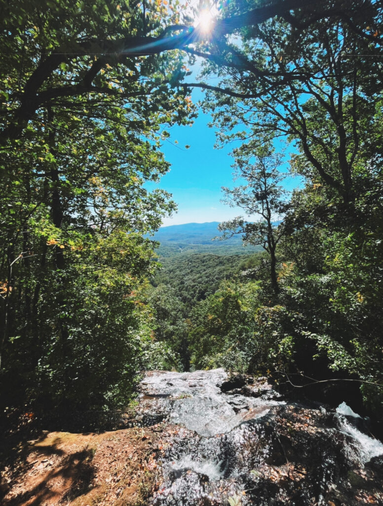 the view from the top of Amicalola Falls with the water rushing over the edge of the rocks 