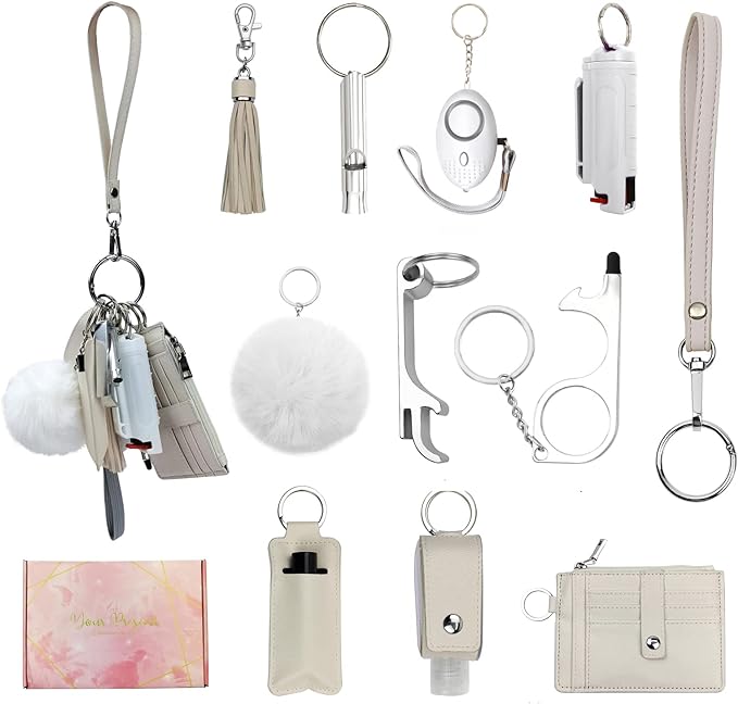A Beige Colored Safety Keychain Set With A Tassle, A Whistle, An Alarm, Pepper Spray, A Puff Ball, A Bottle Opener, A Door Opener, A Wriststrap, A Lipstick/Chapstick Holder, A Hand Sanitizer Holder, And  A Wallet  