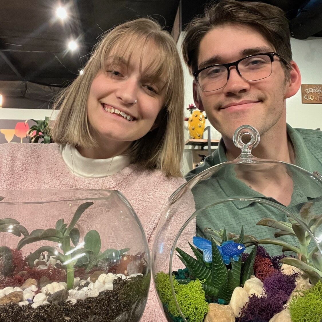 a couple posing with the terrariums they put together
