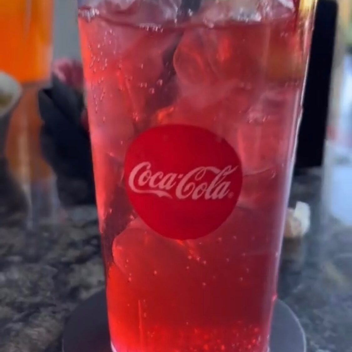 a Shirley Temple drink in a clear Coca-Cola cup 