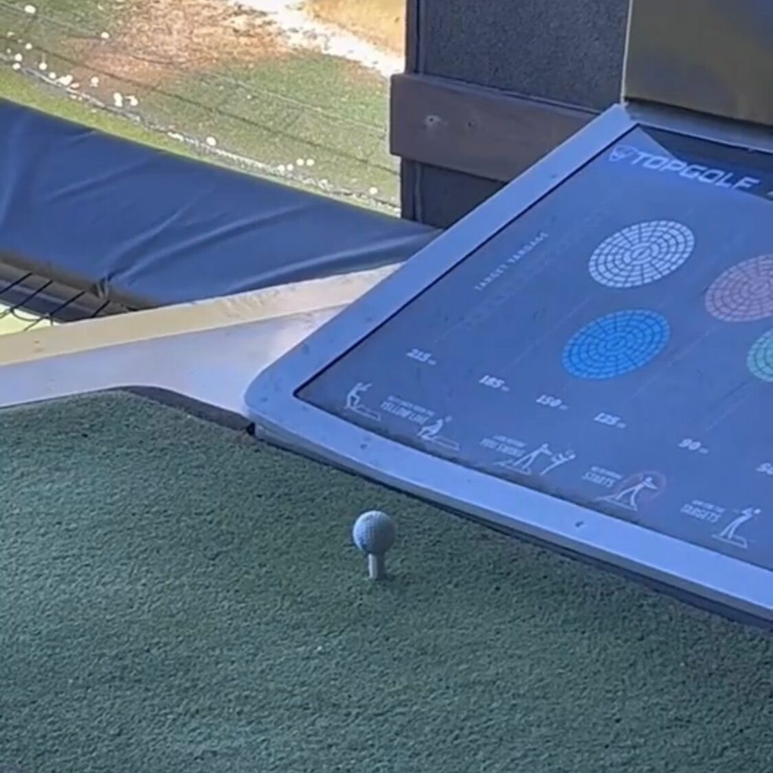 a golfball sitting on the tee at Topgolf