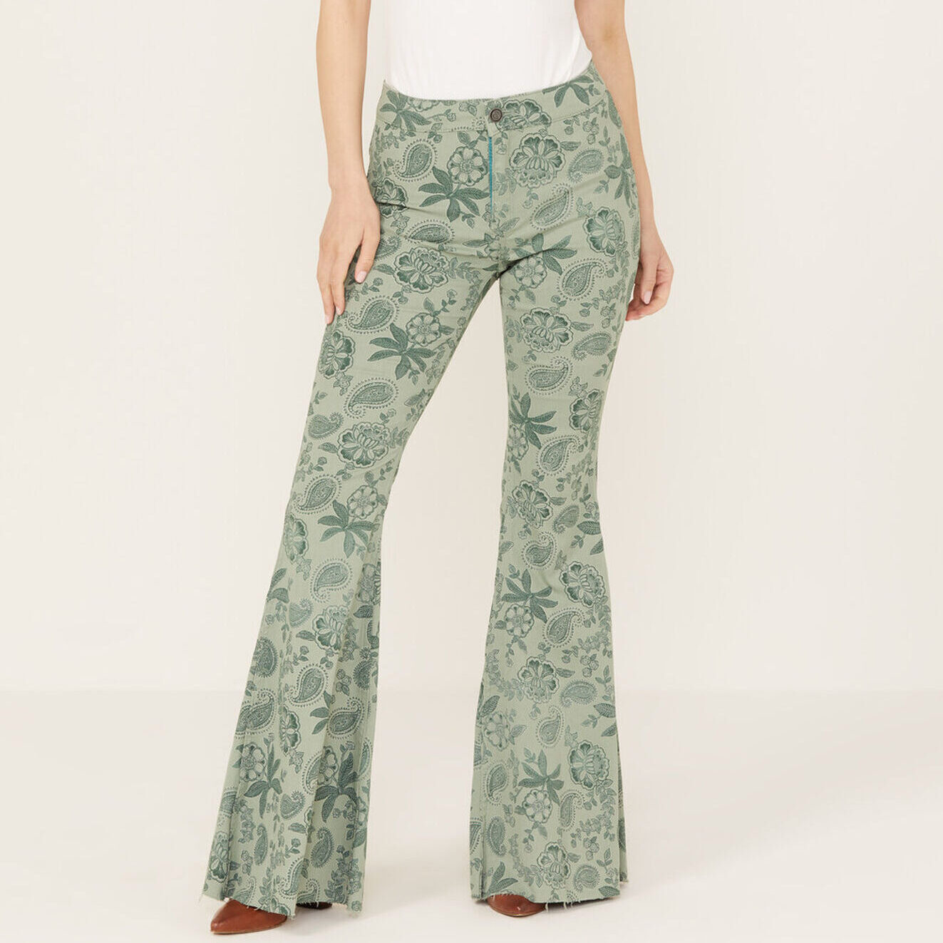 pair of reversible green women's bellbottom pants from Boot Barn, one side is patterned and one side is plain