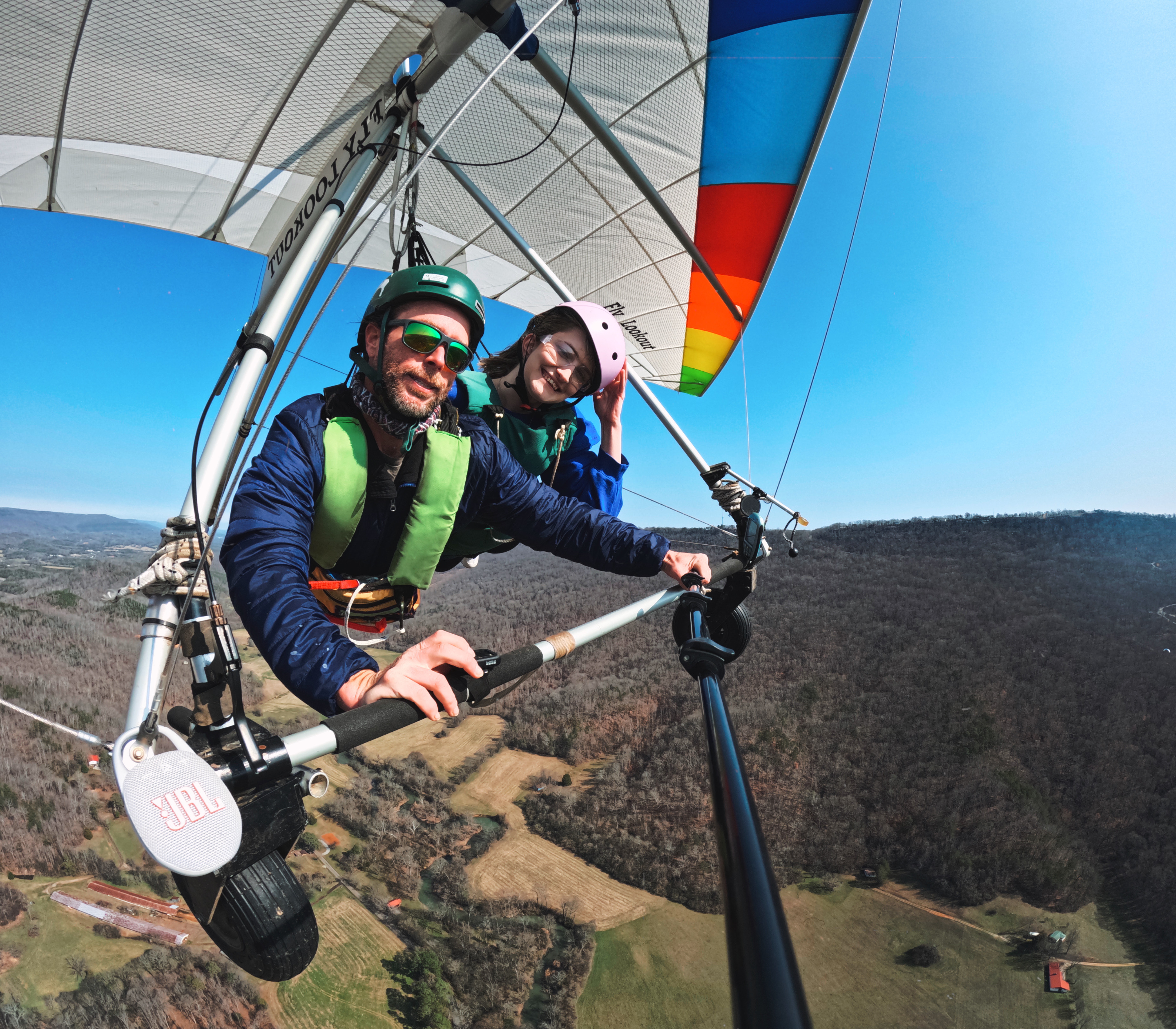 me and an instructor tandem hang gliding and smiling