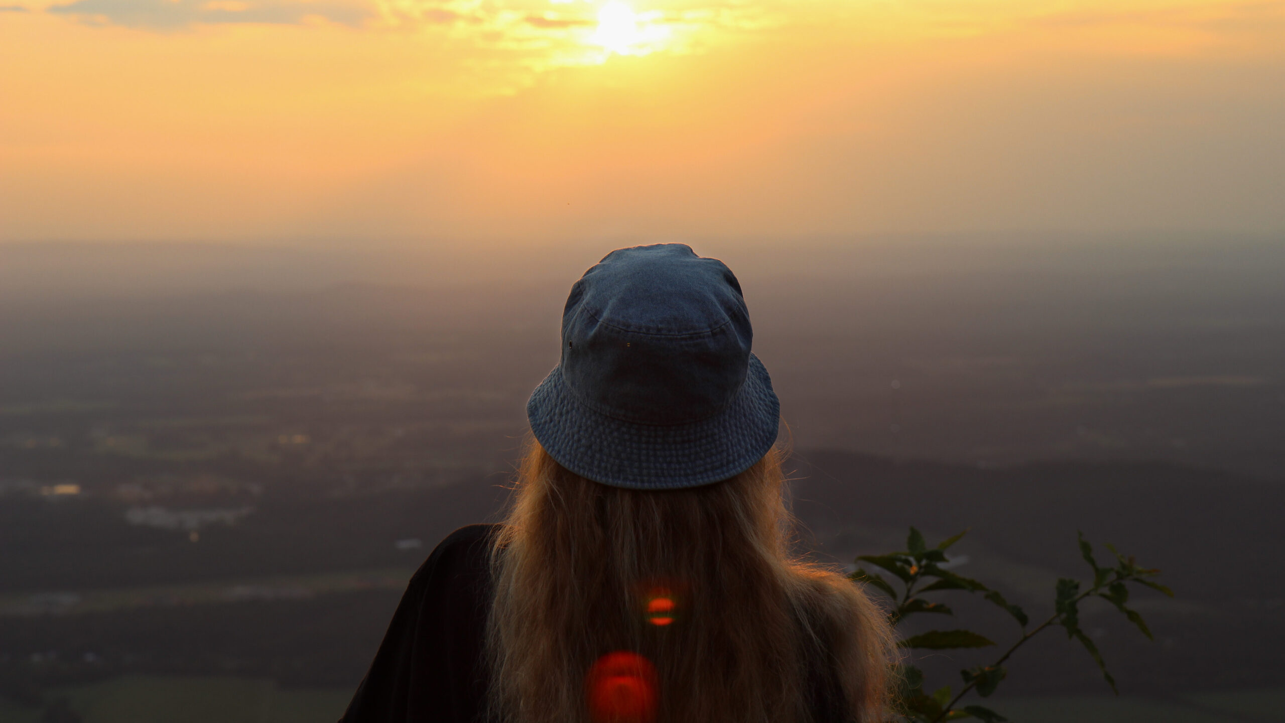 back of a girls head as she looks out to the view from Fort Mountain Overlook as the sun is setting